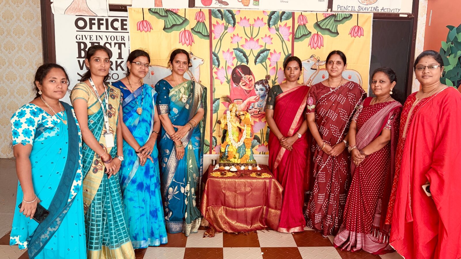 HCS teachers in sarees standing beside the Radha Krishna idol